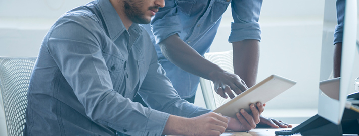 Two business people working on a digital tablet.